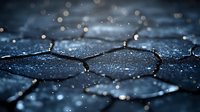 Macro shot of dark hexagonal pattern with water drops and bokeh light effects creating atmospheric moody background with shallow depth of field.