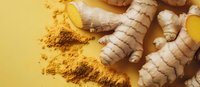 Fresh ginger root and turmeric powder on yellow background, natural spices for cooking, wellness, and alternative medicine applications.