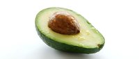 Halved avocado with pit isolated on white background, ready for food photography, culinary design, recipe blogs, nutrition content, and healthy eating marketing materials.