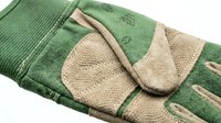 Young woman's hand wearing green and beige knit gloves with textured panels, isolated on white background, suitable for fashion, winter accessories, and lifestyle design projects.
