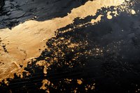 Abstract luxury background with gold metallic paint splatter and black marble texture creating elegant contrast for high-end design projects.