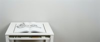 Open book with fashion mode text on white nightstand drawer against neutral background, suitable for interior design and lifestyle projects.