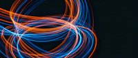 Dynamic light trails creating flowing circular patterns with vibrant blue and orange neon streaks on dark background for modern digital designs.