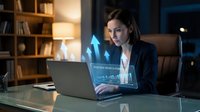 Professional businesswoman analyzing financial data on laptop with holographic display in modern office environment for corporate presentations.
