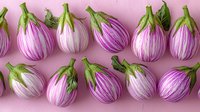 Fresh striped purple and white eggplants with green stems arranged in neat rows on pink background. Organic farm vegetables pattern for healthy eating concept.