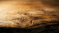 Weathered wood surface with natural grain patterns and warm lighting showcasing rustic texture and organic details for carpentry and interior design projects.