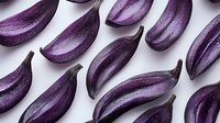 Fresh purple eggplant slices arranged in diagonal pattern on white background, organic produce with glossy skin showing natural texture and color variation.