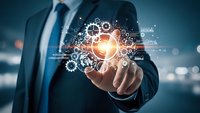 Professional businessman in dark suit holding glowing lightbulb surrounded by floating gear mechanisms representing innovation and technology solutions.