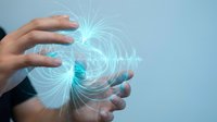 Human hands creating glowing energy sphere with electric blue light rays and magical power effects for technology and innovation concepts.