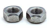 Two weathered metal hex nuts with threaded interior shown in close-up macro photography against white background, isolated for industrial and mechanical designs.