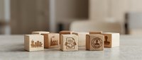 Wooden blocks with engraved logistics and delivery icons arranged in a row on a concrete surface, representing supply chain, transportation, and warehouse management concepts for business.