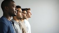 Diverse group of young professional men standing in profile looking forward with hope and determination for business teamwork and leadership concepts.