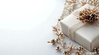 White wrapped present with delicate gold dried flowers and natural decorative elements on light background, creating elegant festive composition for holidays.