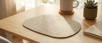 Minimalist beige felt placemat on wooden table with succulent plant and coffee cup creating cozy dining atmosphere for home decor and kitchen styling.