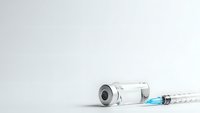 Medical syringe with vaccine vial on clean white background for healthcare and immunization concepts in clinical settings.