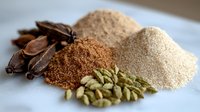 Aromatic spices and seasonings collection with cardamom pods, star anise, nutmeg powder and raw sugar on white surface, macro food photography.