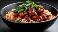 Glazed red meat chunks with sesame seeds and green onions served over ramen noodles in a black bowl, suitable for food photography and restaurant menus.
