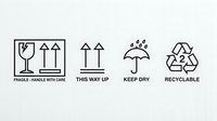 Black shipping and packaging symbols on white background showing fragile glass, this way up arrows, keep dry umbrella and recyclable icons for logistics.
