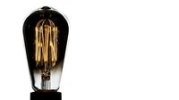 Vintage Edison bulb with warm glowing filament isolated on white background, suitable for lighting design, home decor, and industrial aesthetic projects.