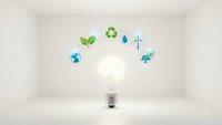 Glowing light bulb surrounded by green energy and environmental icons in clean white room representing sustainable innovation and eco-friendly solutions.