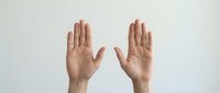 Two open hands raised with palms facing forward in stop gesture against neutral background for communication and body language concepts.