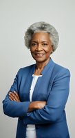 Senior African American woman with gray hair wearing blue blazer and white top, arms crossed, smiling at camera against neutral background for corporate and business use.