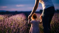 Adult woman and young child holding hands in blooming lavender field at sunset, conveying family bonding, nature connection, and summer outdoor activities for lifestyle and parenting content.