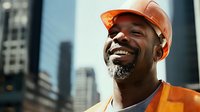 Cheerful African American male construction worker in orange safety vest and hardhat smiling against urban background. Professional portrait showing job satisfaction.
