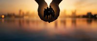 Family protection concept with silhouette of parents and children held in cupped hands against golden sunset background for insurance and care themes.