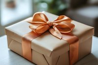 Elegant gift box wrapped in kraft paper with luxurious peach satin ribbon and bow on wooden surface, soft bokeh background creates festive mood.