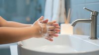 Hands washing with soap and water at bathroom sink. Personal hygiene routine for health and cleanliness. Clean hands under running faucet.