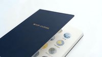Numismatic collection album with navy cover displaying coins in protective sleeves, suitable for currency collectors and hobby enthusiasts organizing precious metal collections.