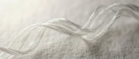 Transparent glass wave flowing across white textured surface, creating fluid motion effect for design, backgrounds, and modern artistic projects.