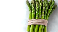 Fresh green asparagus spears bundle tied with natural band on white background, healthy organic vegetable for cooking and nutrition concepts.