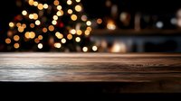 Empty wooden table surface with blurred warm bokeh lights in background creating festive atmosphere for product display or holiday celebration.