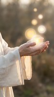 Open palms holding glowing orbs of light with bokeh background, representing hope, spirituality, and healing energy for wellness and inspirational concepts.