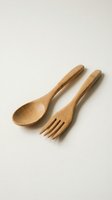 Wooden spoon and fork set on a light background, eco-friendly bamboo cutlery for sustainable kitchen and dining concepts.
