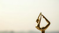 Golden trophy award with elegant curved design against soft blurred background symbolizing achievement, success, recognition and victory in competition.