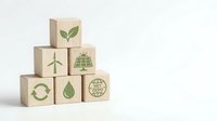 Wooden blocks with green eco-friendly symbols including renewable energy, recycling, and sustainability icons arranged in pyramid formation on white background.