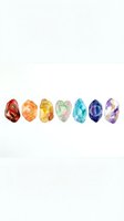 Seven colorful gemstones arranged in a row, isolated on white background, featuring red, orange, yellow, green, pink, blue, and purple crystals for jewelry design and decoration projects.