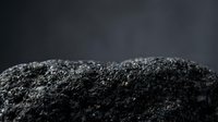 Black activated charcoal powder pile on dark background for detox skincare cosmetics natural health supplements and water filtration applications.