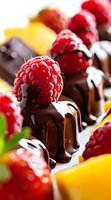 Fresh raspberries on dark chocolate dessert pieces with dripping melted chocolate sauce, macro food photography showing rich textures and vibrant colors.