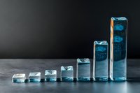 Growing blue glass blocks arranged in ascending order on dark background showing business growth concept and progression chart visualization.