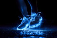 Glowing blue sneakers with luminous energy effect on dark background, floating with magical light trails and particles for sports and fantasy concepts.