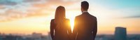 Romantic couple silhouettes holding hands watching beautiful sunset sky with warm golden light creating intimate moment for love and relationship concepts.