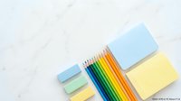 Colorful pencils with sticky notes on white marble surface for office supplies, education, creativity and workspace organization projects.