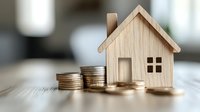 Wooden house model with stacked coins on table representing real estate investment, mortgage savings, property finance and home buying budget planning.