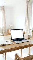 Laptop with blank screen on wooden desk in bright, minimalist workspace with open notebook, pen, coffee mug, and potted plant for remote work and productivity concepts.
