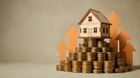 Wooden house model on stacks of golden coins with upward arrows showing real estate investment growth and property value appreciation concept.