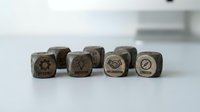 Wooden business stamp set with corporate icons including gears, handshake and strategy symbols for office branding and document marking on white surface.